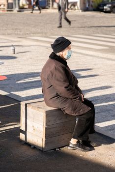 11-22-2020. Prague, Czech Republic. People during quarantine period due to coronavirus (COVID-19) at Hradcanska metro stop in Prague 6. Old woman sitting.
