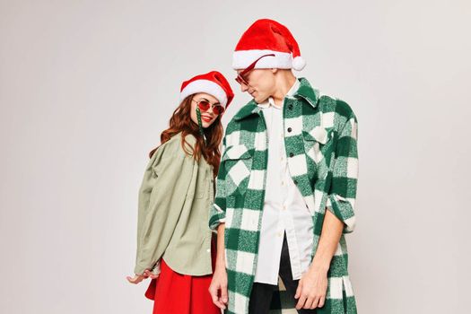 Man and woman in Christmas hats with sunglasses studio fashion holiday. High quality photo