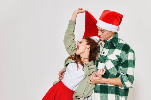 A man holds a woman in his arms a Christmas hat holiday emotions gifts Friendship gray background. High quality photo