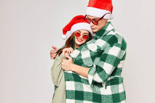 A man and a woman are hugging together in Christmas hats, sunglasses, holiday together. High quality photo