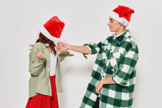 Man and woman wearing New Year's clothes caps emotions holiday Christmas studio gray background. High quality photo