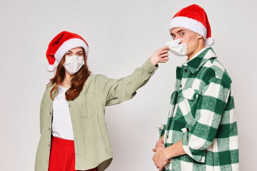 young couple wearing medical masks protecting new year holiday together. High quality photo