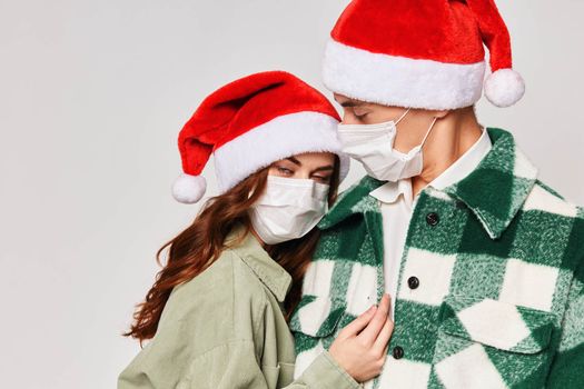 man and woman wearing medical masks hug holiday new year close-up. High quality photo