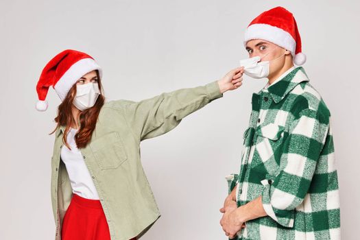 Man and woman in New Year's hats medical masks quarantine holiday New Year. High quality photo