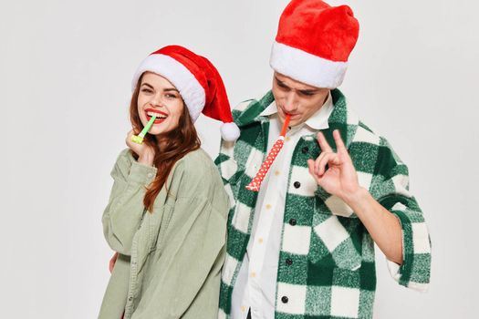 cheerful young couple wearing new year's clothes festive pipes mood new year. High quality photo