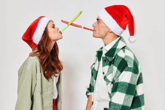 young couple christmas hats pipes holiday relationship fun. High quality photo