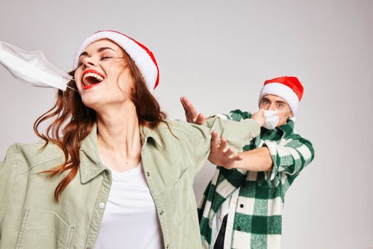 Man and woman in Christmas caps medical mask emotions fun together New Year. High quality photo