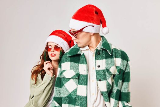 Cute young couple wearing sunglasses Christmas hats fun holiday. High quality photo