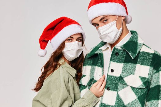 young couple wearing medical masks christmas hats holiday close-up. High quality photo