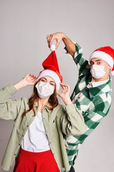 young couple wearing medical masks on their face christmas fun friendship holiday. High quality photo