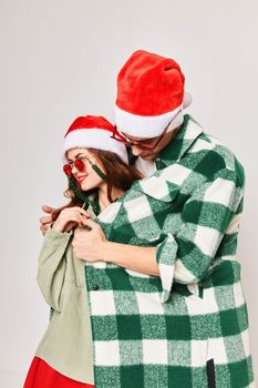 A man warms a woman with a shirt Christmas hats holiday fun dark glasses. High quality photo