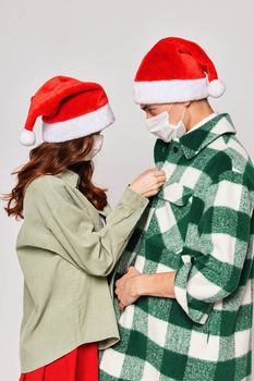 Woman buttons shirt man Christmas hats caring winter Christmas. High quality photo