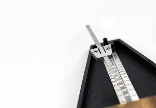 Detail of the pendulum of a classic metronome. Rhythm measurement tool. Mechanical movement without electricity