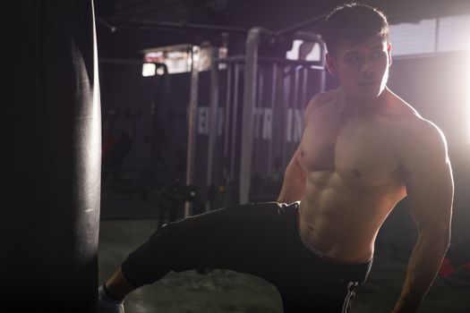 Fitness man doing kick boxing training in sport gym