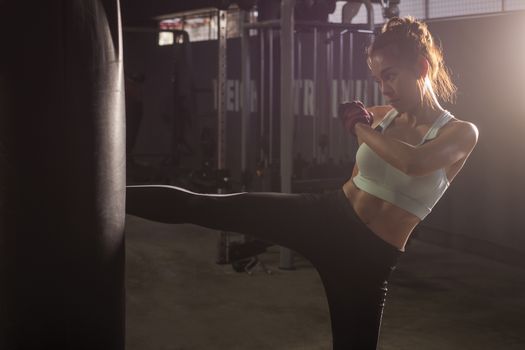 Fitness girl doing kick boxing training in sport gym