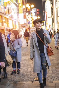 Beautiful smiling woman tourists traveling in walking at street shopping center Shibuya in Tokyo, Japan.