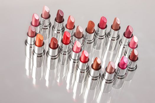 Tubes with different kinds of lipstick on studio background