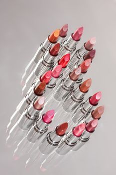 Tubes with different kinds of lipstick on studio background