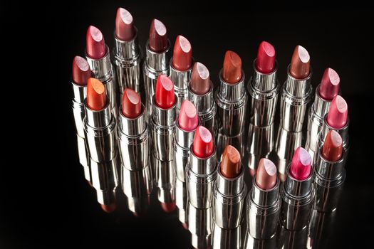 Tubes with different kinds of lipstick on studio background