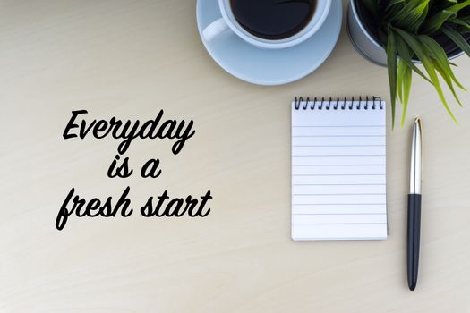 EVERYDAY IS A FRESH START text with fountain pen, notepad, decorative flower and cup of coffee on wooden background. Business and copy space concept.
