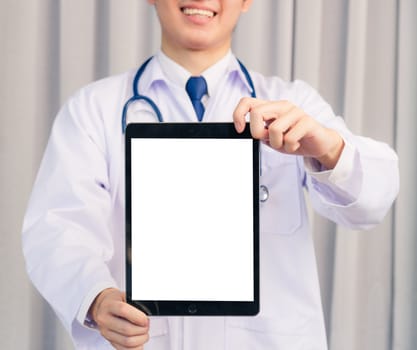 Portrait closeup of Happy Asian young doctor handsome man smiling in uniform and stethoscope neck strap showing front blank screen smart digital tablet on hand, Healthcare medicine concept