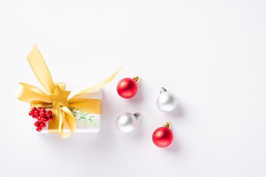 Christmas holiday composition top view flat lay of with a gift box and gold ribbon, fir branches, pine cones, and candy with copy space isolated on white background, New year day concept