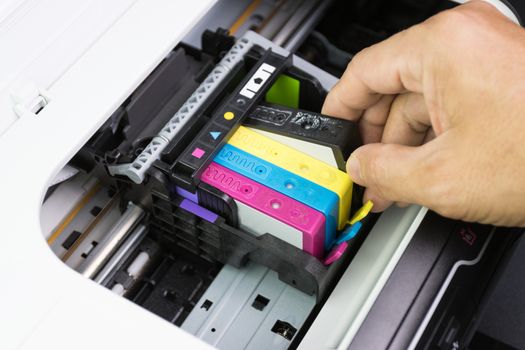 Technicians are install setup the ink cartridge of a inkjet printer the device of office automate for printing