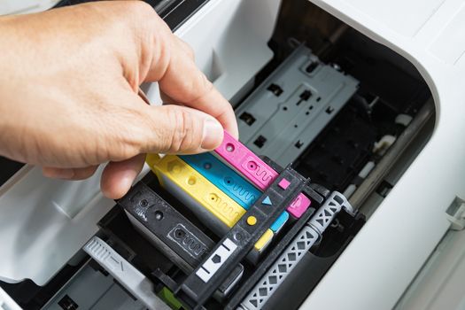 Technicians are install setup the ink cartridge of a inkjet printer the device of office automate for printing