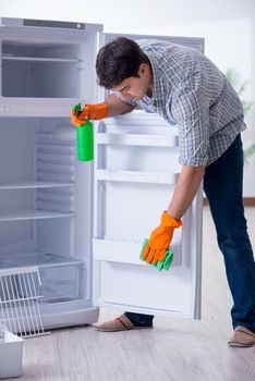 Man cleaning fridge in hygiene concept