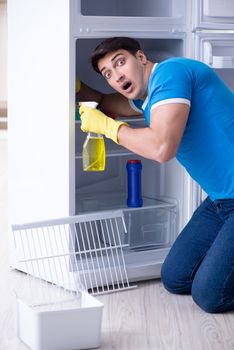 Man cleaning fridge in hygiene concept