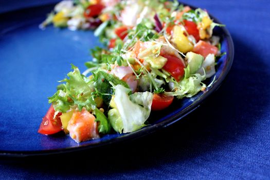 Fresh vegetable salad on a blue background.Texture or background