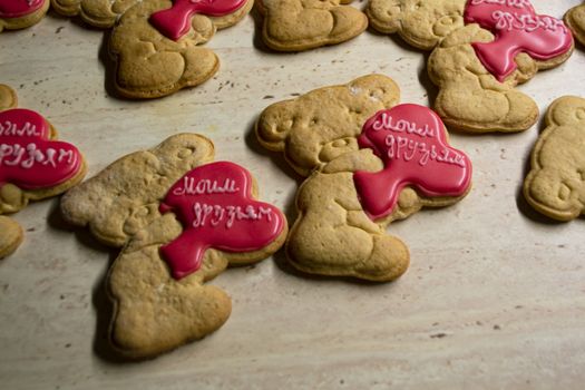 brown gingerbread cookies in the shape of bears with red hearts