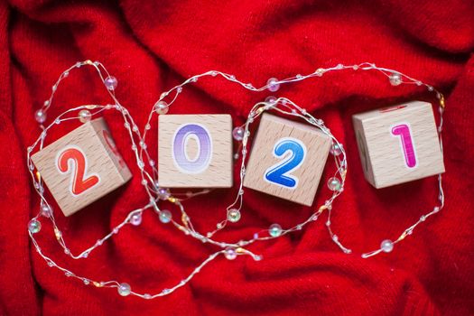 Numbers 2021 from children's cubes on a bright red background. New Year Christmas