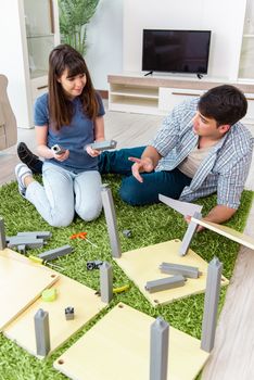 Young family assembling furniture at new house