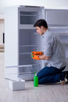 Man cleaning fridge in hygiene concept