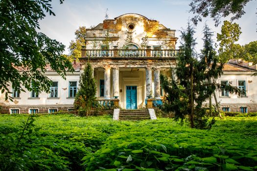 Old abandoned manor in the forest. Ruined house in nature