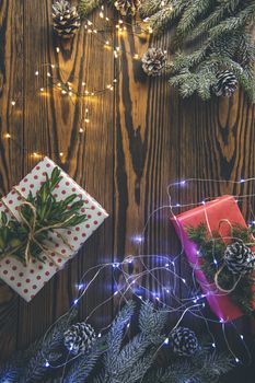 Christmas background with gift box wrapped in holiday paper over wooden table prepared for celebrating festive holiday season. Copy space.