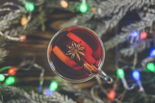 Christmas hot mulled wine in a glass with spices and citrus fruit. Mulled wine with cinnamon, anise and orange. Top view and copy space.