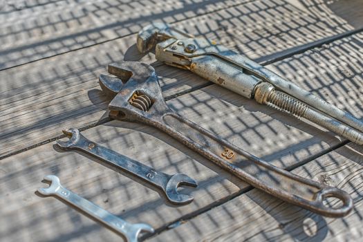 Set of wrenches and adjustable wrenches on a wooden floor