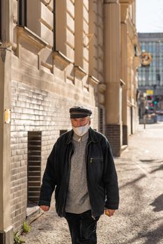 11-23-2020. Prague, Czech Republic. People walking and talking outside during coronavirus (COVID-19) at Hradcanska metro stop in Prague 6. Old man walking with mask.