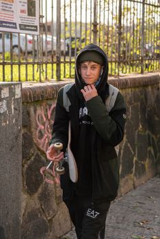 11-23-2020. Prague, Czech Republic. People walking and talking outside during coronavirus (COVID-19) at Hradcanska metro stop in Prague 6. Young man smoking and walking.