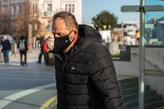 11-23-2020. Prague, Czech Republic. People walking and talking outside during coronavirus (COVID-19) at Hradcanska metro stop in Prague 6. Man walking with mask..