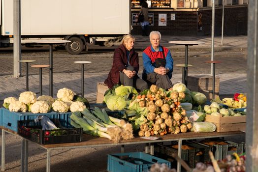 11-23-2020. Prague, Czech Republic. People walking and talking outside during coronavirus (COVID-19) at Hradcanska metro stop in Prague 6. Old couple at market.