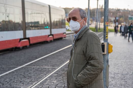 11-23-2020. Prague, Czech Republic. People walking and talking outside during coronavirus (COVID-19) at Hradcanska metro stop in Prague 6. Man with mask crossing.