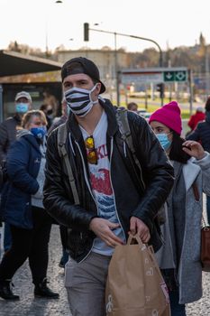 11-23-2020. Prague, Czech Republic. People walking and talking outside during coronavirus (COVID-19) at Hradcanska metro stop in Prague 6. Man getting out the tram.