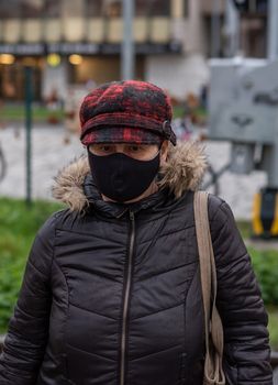 11-23-2020. Prague, Czech Republic. People walking and talking outside during coronavirus (COVID-19) at Hradcanska metro stop in Prague 6. Woman with mask.