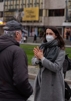 11-23-2020. Prague, Czech Republic. People walking and talking outside during coronavirus (COVID-19) at Hradcanska metro stop in Prague 6. Woman with mask.