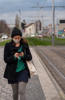11-23-2020. Prague, Czech Republic. People walking and talking outside during coronavirus (COVID-19) at Hradcanska metro stop in Prague 6. Woman with mask.