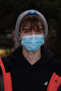 11-23-2020. Prague, Czech Republic. People walking and talking outside during coronavirus (COVID-19) at Hradcanska metro stop in Prague 6. Portrait of young man with mask.