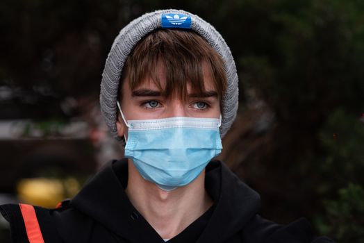 11-23-2020. Prague, Czech Republic. People walking and talking outside during coronavirus (COVID-19) at Hradcanska metro stop in Prague 6. Portrait of young man with mask.